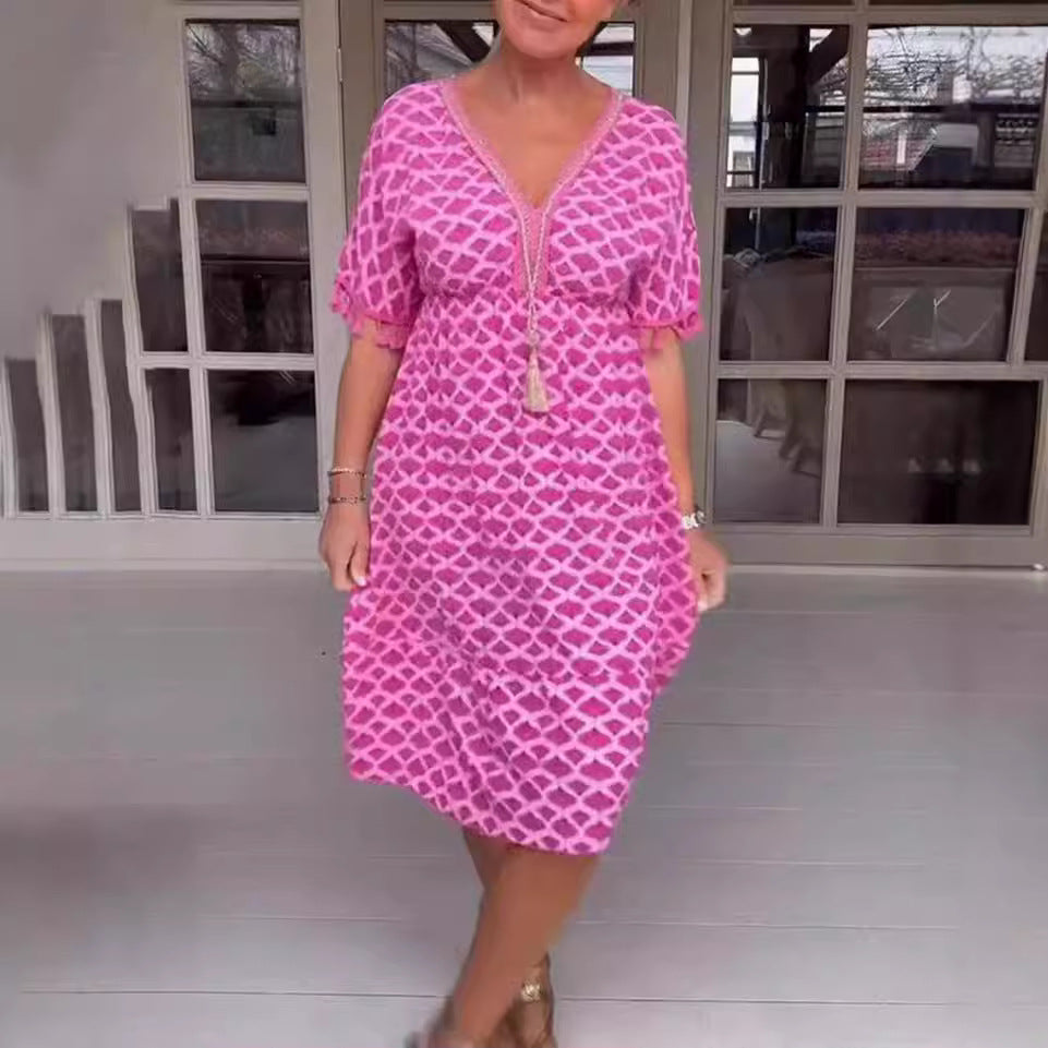 Damklänning midi – avslappnad passform – V-ringning med tofsdetalj – geometriskt mönster