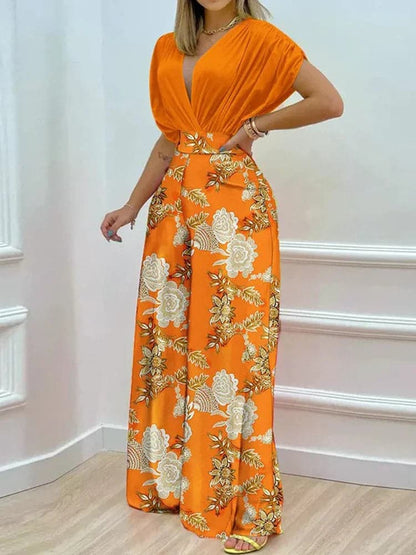 Dambyxa Jumpsuit - Djup V-ringning - Korta Ärmar - Vid Benpassform - Elegant Blommig Design