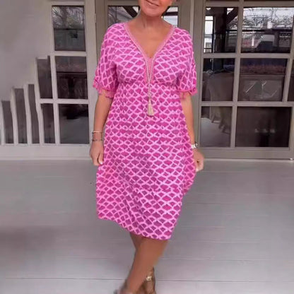 Damklänning midi – avslappnad passform – V-ringning med tofsdetalj – geometriskt mönster