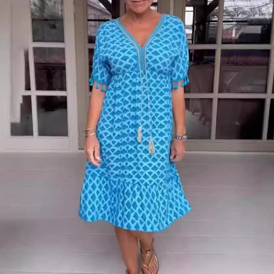 Damklänning midi – avslappnad passform – V-ringning med tofsdetalj – geometriskt mönster