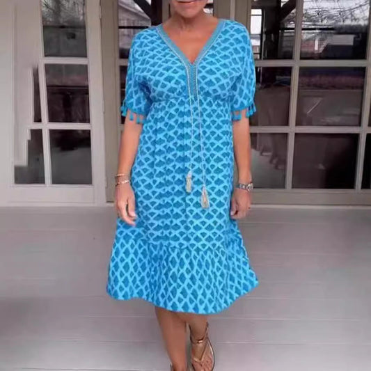 Damklänning midi – avslappnad passform – V-ringning med tofsdetalj – geometriskt mönster