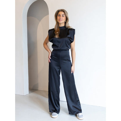 Dam jumpsuit – Satinfinish – Ärmös – Hög hals – Öppen rygg – Vida ben – Elegant passform